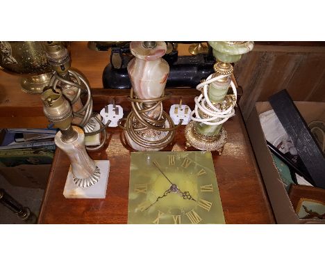 A brass and onyx standard lamp with four similar table lamps and an onyx clock