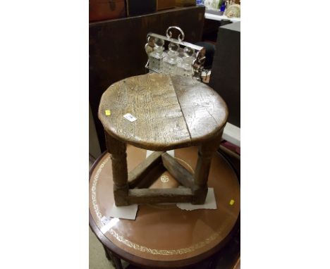 An antique oak joint stool with circular top