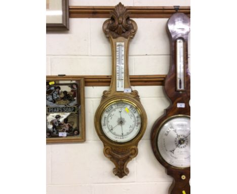 An early 20th Century carved oak aneroid barometer