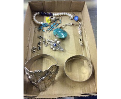 A white metal bangle; an Eastern amulet and various other items of jewellery 