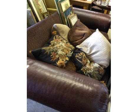 A large leather and fabric upholstered sofa with a quantity of cushions 