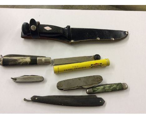 A box containing four pocket knives; a cut throat razor; a Dunlop pressure gauge and a knife