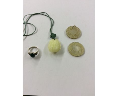 A carved jade floral pendant; two mother of pearl carved pendants and a silver and jade set ring