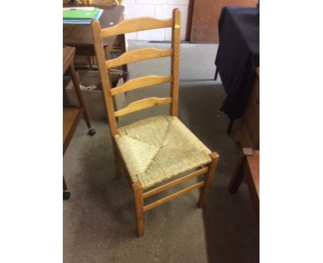 A set of four pine ladder back and rush seated dining chairs 