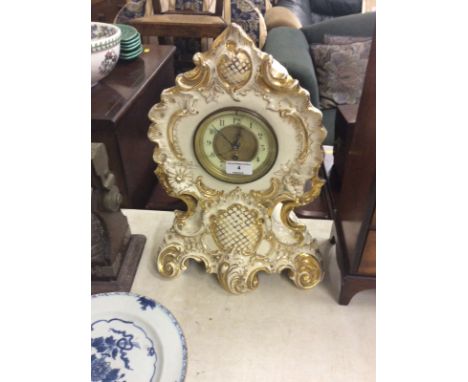 An early 20th Century china cased and gilt decorated single hole mantel clock - key and pendulum on rostrum 