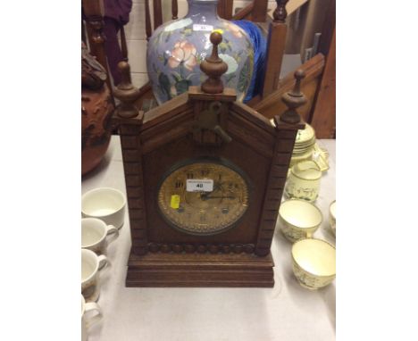 An oak cased two hole mantel clock with gilded dial