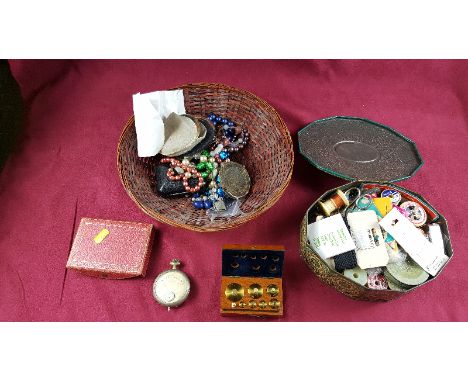 A tin of sewing items; a basket containing costume jewellery; a volt meter; a set of small brass weights; a compact etc.