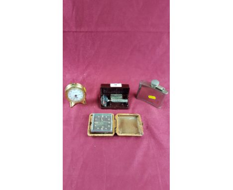 A silver plated hip flask; a leather cased alarm clock; a small brass cased bedside clock and a Bakelite cased razor