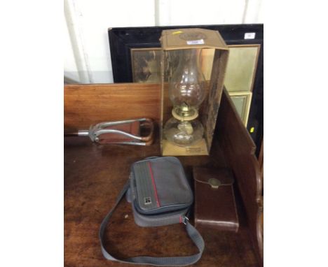 A shooting stick; a glass oil lamp; and two cameras 