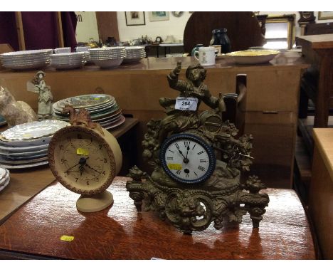 A French Spelter figural decorated single hole mantel clock together with a pottery mantel clock