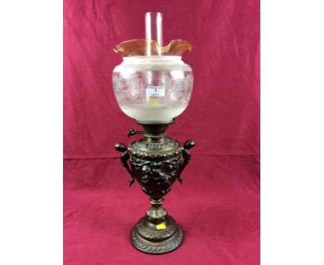 A brass figural decorated oil lamp with etched glass shade 