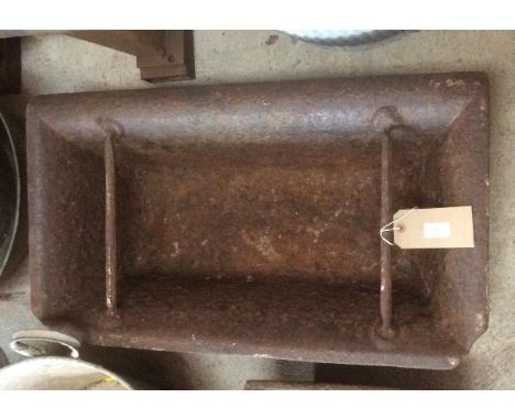 A large rectangular cast iron feeder drilled out as a planter