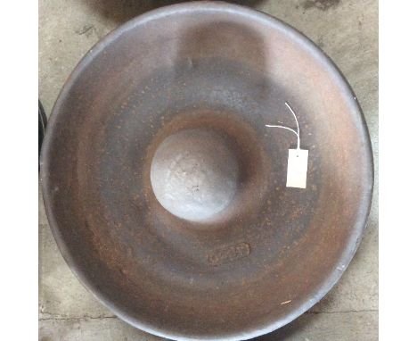 A circular cast iron pig trough, named to Asco