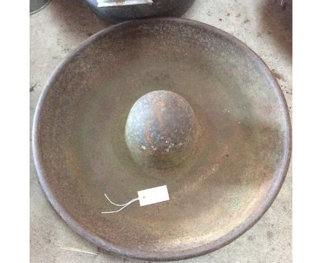A circular cast iron pig trough