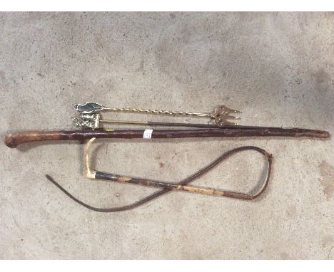 A brass toasting fork; a brass handled poker; riding whip; and a wooden walking stick 