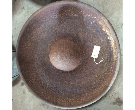 A circular cast iron pig trough