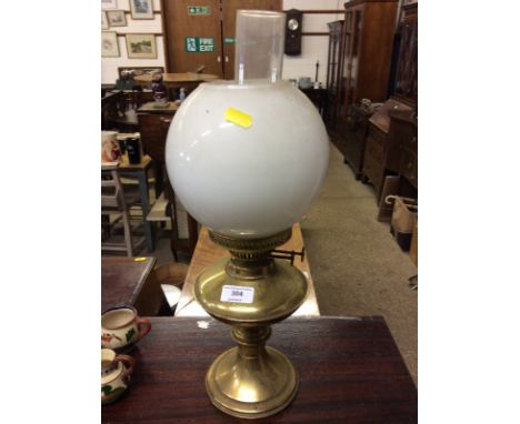 A brass oil lamp with milk glass shade