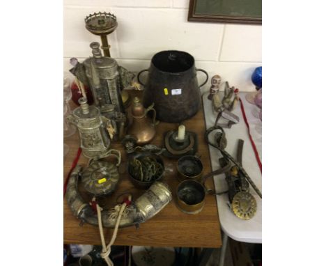 An Eastern horn and metal mounted powder flask; three other similar vessels; a brass candlestick; an Eastern copper two handl