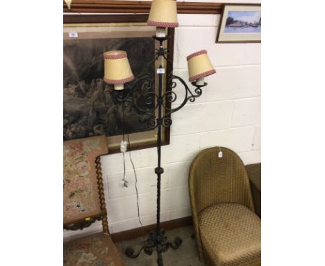 A wrought iron three branch standard lamp