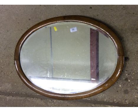 An oval framed wall mirror; a Religious print; and one other wall mirror 