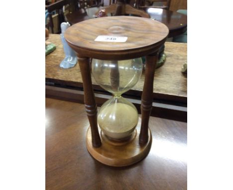 A turned wooden and glass egg timer 