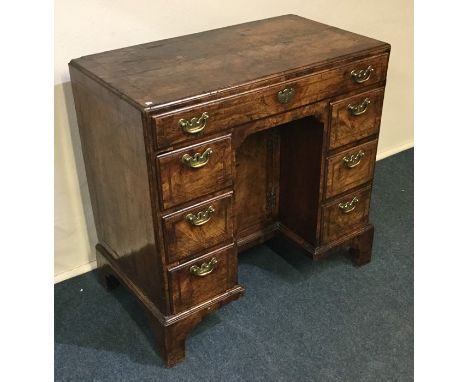 A good quality Georgian seven drawer knee hole desk with central cupboard and brass handles to bracket feet. Est. £400 - £600