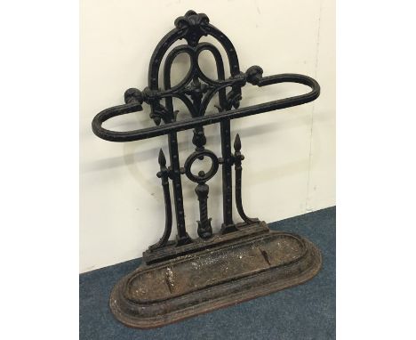 A large wrought iron stick stand decorated with scrolls on tapering feet. Est. £100 - £120.