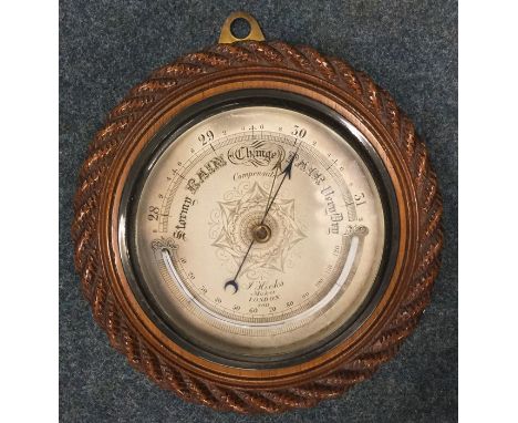 A small oak framed barometer with silvered dial. Est. £30 - £50.