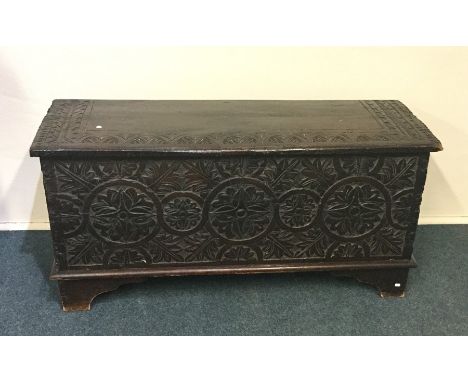 An early Georgian hinged top coffer decorated with flowers and leaves on bracket feet. Est. £100 - £200.