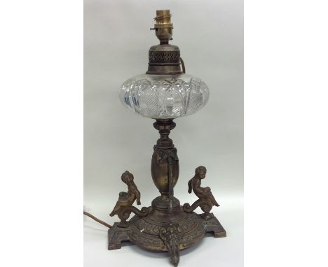 A cut glass mounted oil lamp, the base decorated with figures and swags to bracket feet. Approx. 40 cms high. Est. £40 - £60.