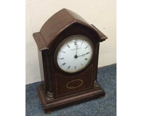 An Edwardian inlaid mantle clock on brass bun feet. Est. £50 - £80.