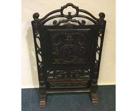 A large Continental fire screen decorated with tribal figures on bracket feet. Approx. 110 cms high. Est. £100 - £150.