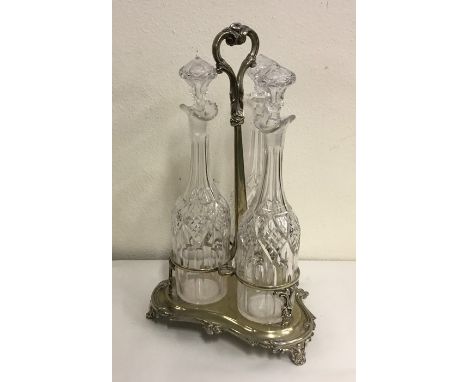 A good tall three bottle tantalus with cut glass bodies to scroll feet. Approx. 42 cms high. Est. £150 - £200.