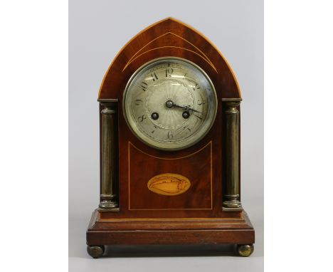 An early C20th mahogany mantel clock with Arabic numeral dial enclosing twin train movement along with a shell paterae raised