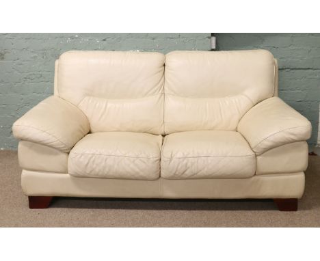 A cream leather two seater sofa.