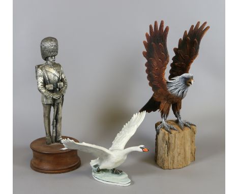A Goebel figure of a swan with wings outstretched along with a pewter figure of a soldier and a composite golden eagle.