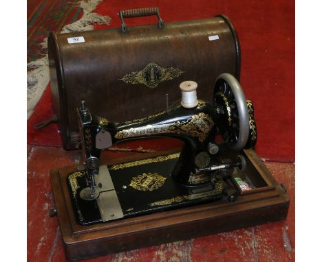 A cased manual Singer sewing machine.