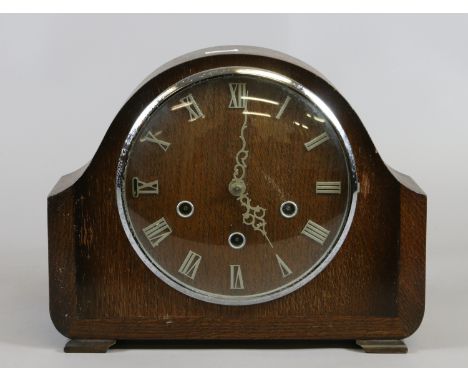 An early C20th oak mantel clock with Roman numeral dial enclosing Westminster chime movement, pendulum and keys.