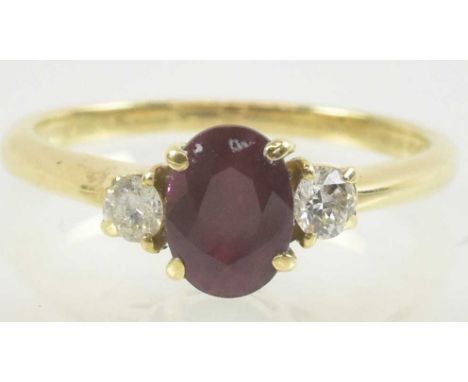 An 18ct yellow gold ruby and diamond set ring, the central ruby approx 0.5ct, flanked by two small diamonds, each approx 0.1c