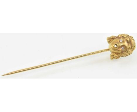 An 18ct yellow gold hat pin, the top surmounted with figural decoration of a head, the eyes set with small diamonds, length 5