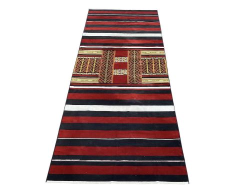 A modern Turkish Kilim style carpet with black, white and red striped decoration and geometric designs, 540 x 200cm.