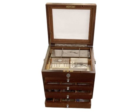 A mid century dentist's tool box, with hinged lid above four drawers containing dental tools.