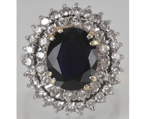 An 18ct white gold sapphire and diamond cluster ring, the forty-three stone oval shaped cluster comprising a central dark ova