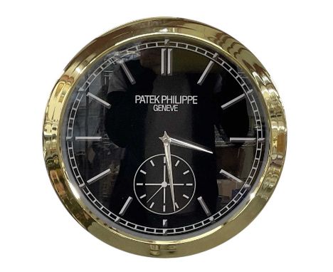 A decorative Patek Philippe style dealer's wall clock, the black dial set with subsidiary seconds and hour markers, inscribed