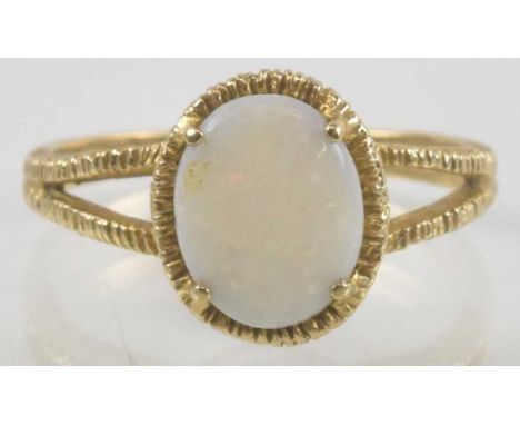 A 9ct gold opal set ring, the oval claw set opal in textured mount, on split shoulders, size P, approx 2.7g.