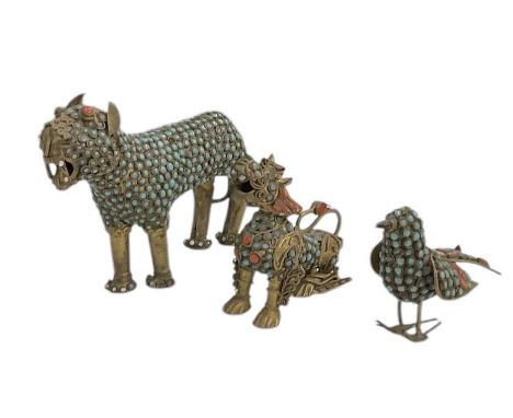 Three Tibetan brass and jewelled animals, including two temple dogs set with turquoise and coral beads, the larger height 9cm