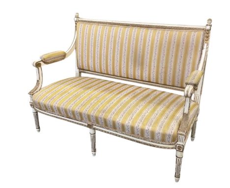 A late 19th/early 20th century French white and gilt painted settee, width 135cm.