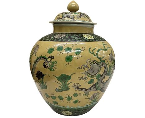 A Chinese beige ground porcelain lidded urn, decorated with dragons amongst foliage, height 32cm.