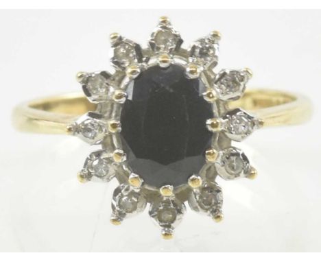 A 9ct gold diamond and sapphire set ring, the central oval cut sapphire within a floral border of tiny diamond chips, size O,