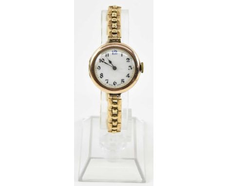 A 9ct gold lady's wristwatch, the white enamel dial set with Arabic numerals and blue 12 o'clock, on 9ct gold bracelet, combi